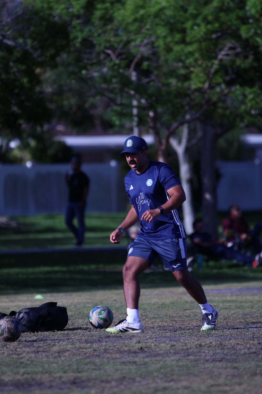 Coach Ricardo Cuenca demonstrating with a soccer ball during training